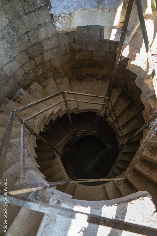 Fototapeta premium Creepy dusty hexagonal stairs on an abandoned building