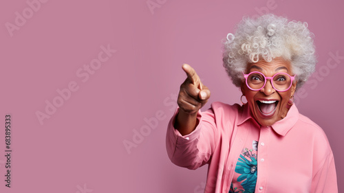 Happy senior afro woman points her finger at copy space for promotion