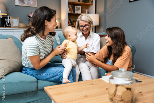 Happy family. Grandmother, mother, aunt and little baby having fun at home. Relatives visiting new born child.