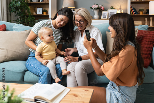 Happy family. Grandmother, mother, aunt and little baby having fun at home. Relatives visiting new born child.