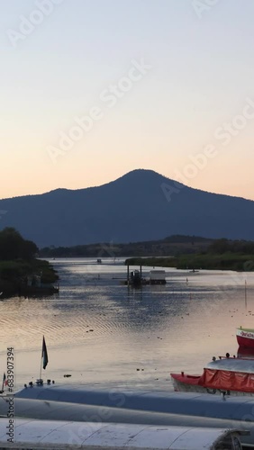 Boats and Dock at sunset with mountain in the background.