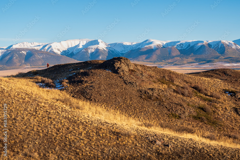 Hiking in the mountains. Amazing snowy mountain landscape. Siberian high mountain ice peak and Altai background sunny sky. Natural scenery of autumn mountain forest.