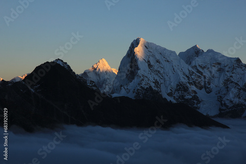 Sun lit mountains Ama Dablam and Cholatse at sunset, Nepal.