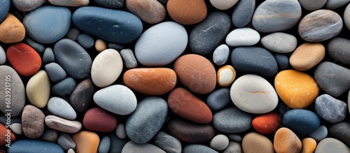 The abstract design of the beach, with its textured and colorful sea stones, provides a beautiful and natural background that mesmerizes and captivates anyone who beholds its breathtaking beauty