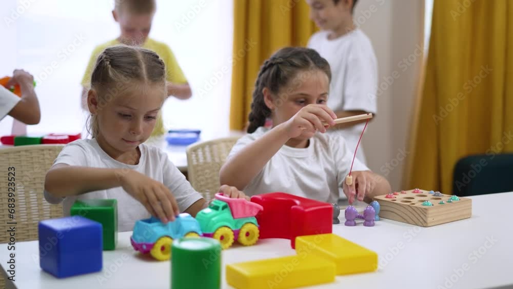 Happy team group of children in kindergarten school play together as team in educational games build colored cubes house.team of children play at home at school in color cubes support friend together Happy team group of children in kindergarten school play together as team in educational games build colored cubes house.team of children play at home at school in color cubes support friend together
