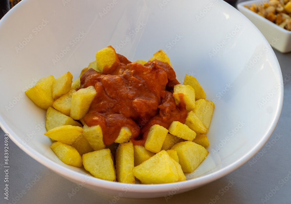 Patatas bravas on a white bowl, spanish tapas Patatas bravas on a white bowl, spanish tapas