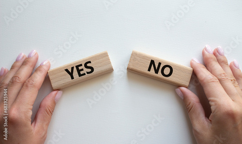 Yes or No symbol. Concept word Yes or No on wooden blocks. Businessman hand. Beautiful white background. Business and Yes or No concept. Copy space