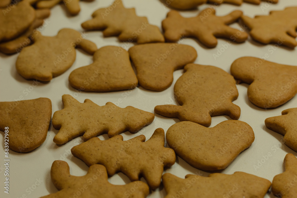 Ready gingerbread cookies on a white table. Christmas brown cookies. Festive background. Sweet homemade cakes for children. Ready gingerbread cookies on a white table. Christmas brown cookies. Festive background. Sweet homemade cakes for children.