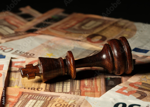 Closeup photo of a chess piece on a board of euro bills
