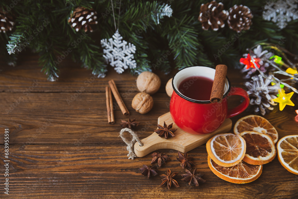 Christmas mood, holiday atmosphere. Red cup of coffee, fir branches with cones, walnuts, cinnamon, star anise on a wooden table background. Christmas mood, holiday atmosphere. Red cup of coffee, fir branches with cones, walnuts, cinnamon, star anise on a wooden table background.