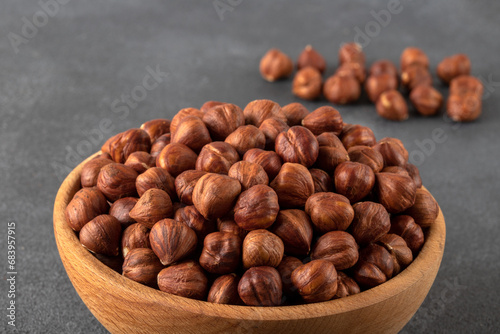 View of a bowl full of hazelnuts on a black background 