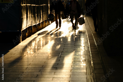 大都会で夕陽に照らされてビジネスマンを逆光でシルエットで撮影、影が長く伸びる、冬の季節大阪梅田で撮影。 photo