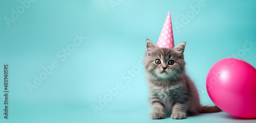 Kitten in Pink Party Hat with a Pink Balloon on a Soft Blue Background. Banner, card, birthday party invitation.
