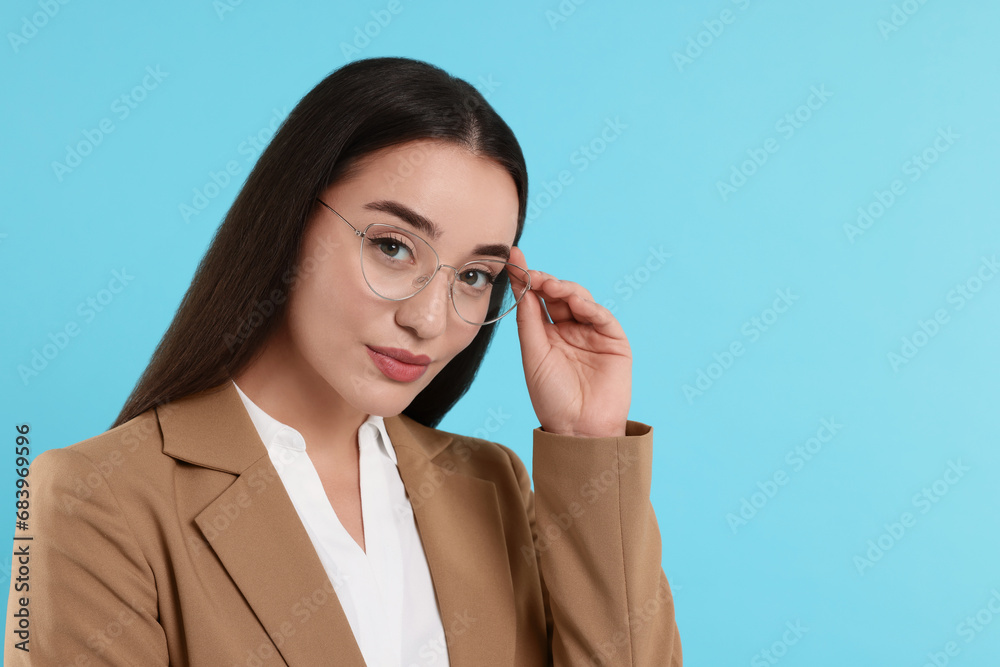 Beautiful woman wearing glasses on turquoise background, space for text Beautiful woman wearing glasses on turquoise background, space for text