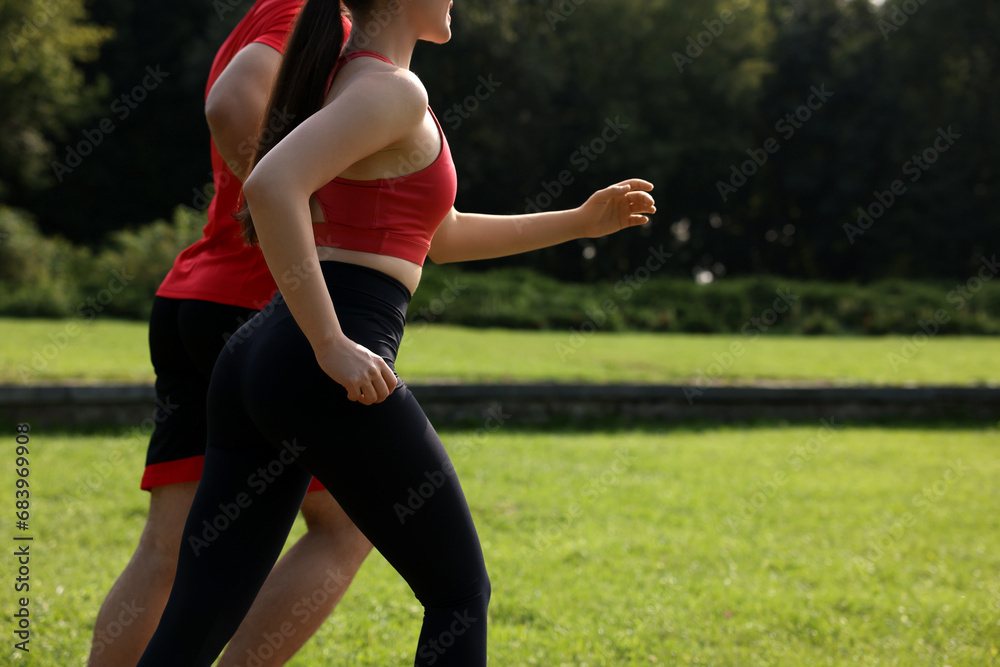 Healthy lifestyle. Couple running in park on sunny day, closeup Healthy lifestyle. Couple running in park on sunny day, closeup