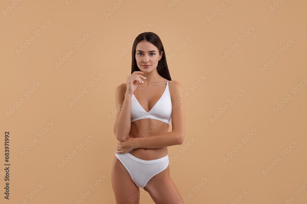 Young woman in stylish white bikini on beige background Young woman in stylish white bikini on beige background