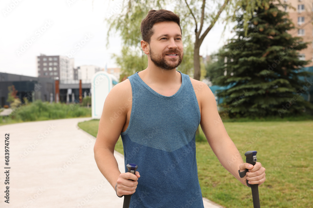 Man practicing Nordic walking with poles outdoors