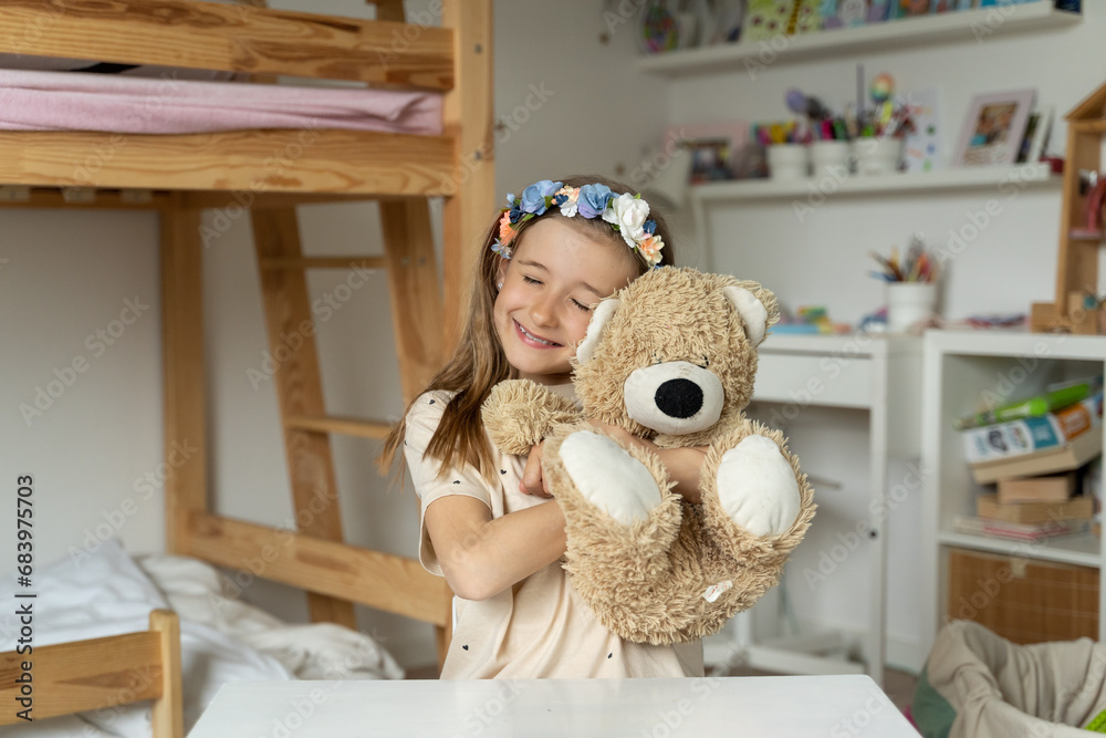 happy little girl in her play room with teddy bear hugs lonely, love,
