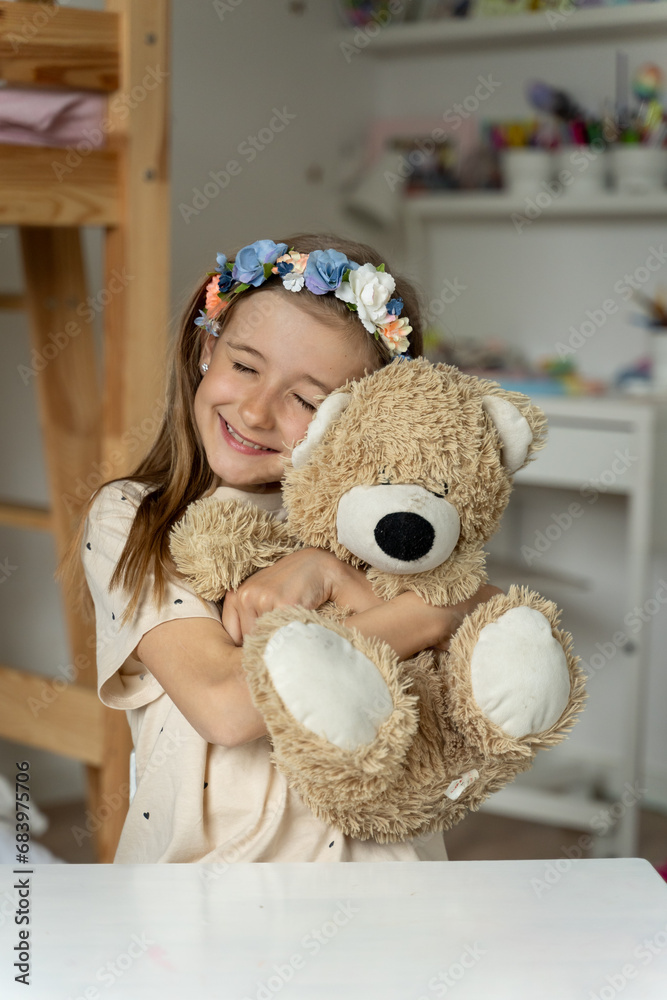 happy little girl in her play room with teddy bear hugs lonely, love,