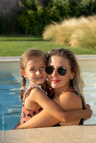 Obraz na płótnie happy daughter and mom enjoy summer fun at the pool blue water happy love w salonie