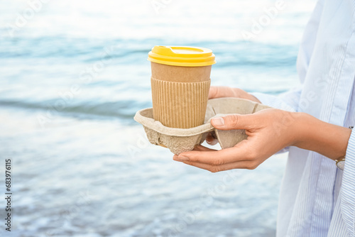 Woman holding paper coffee ...