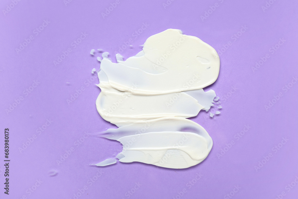 Smears of cream on lilac background