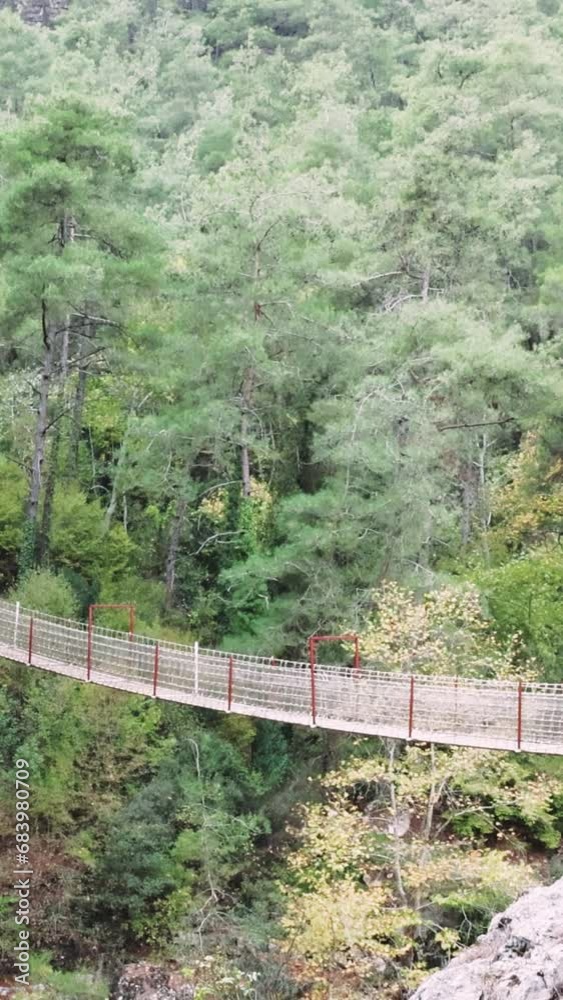 Hiking adventure over wooden bridge in Kapikaya Canyon, crossing mountain river. Wooden bridge serves as a scenic footbridge for hikers. Footbridge in Kapikaya, a highlight for hiking enthusiasts Hiking adventure over wooden bridge in Kapikaya Canyon, crossing mountain river. Wooden bridge serves as a scenic footbridge for hikers. Footbridge in Kapikaya, a highlight for hiking enthusiasts