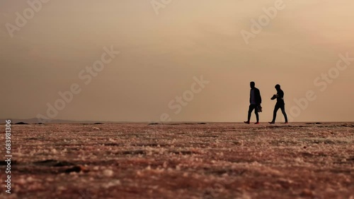 Silhouette of People Walking with Bare Feet on Dry Salt Lake Turkey photo
