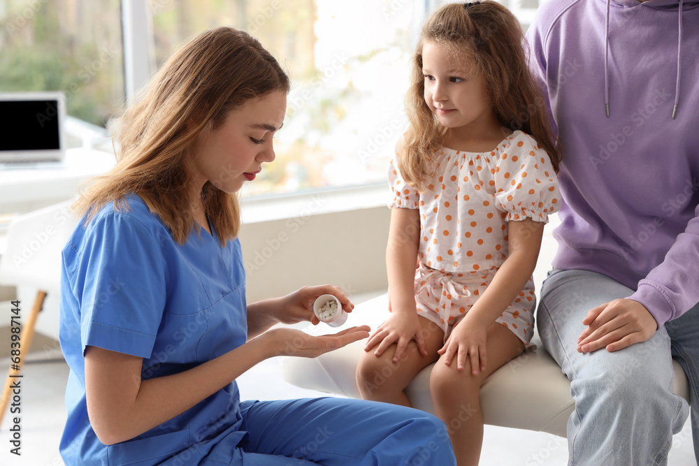 Sick little girl with her mother visiting doctor in clinic