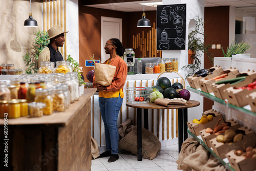 Canvas Print African American shopkeeper and customer discuss eco friendly, pantry staples and fresh produce