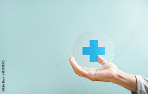 Hand grips plus icon for healthcare, highlighting benefits. Health insurance health concept, access to welfare health with available room. Conveys value addition in medical care.