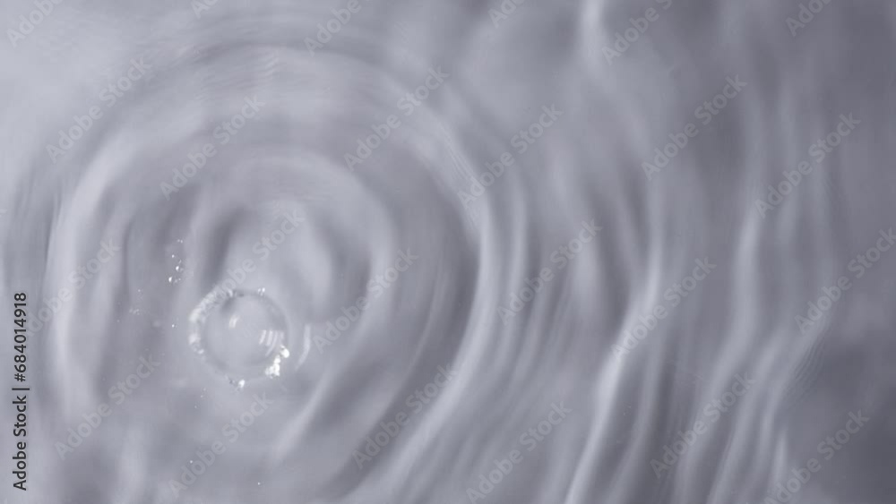 Drop of water falling down and making circles on surface. Slow motion. Closeup Drop of water falling down and making circles on surface. Slow motion. Closeup