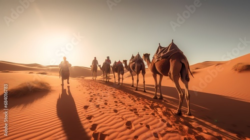 Caravan with group of tourists riding camels through Dubai desert during safari adventure photo