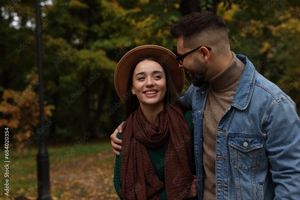 Romantic young couple spending time together in autumn park, space for text Romantic young couple spending time together in autumn park, space for text