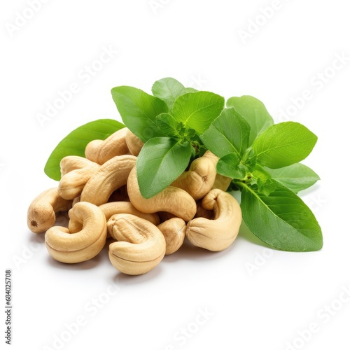 Roasted cashew nuts with green leaves isolated on white background