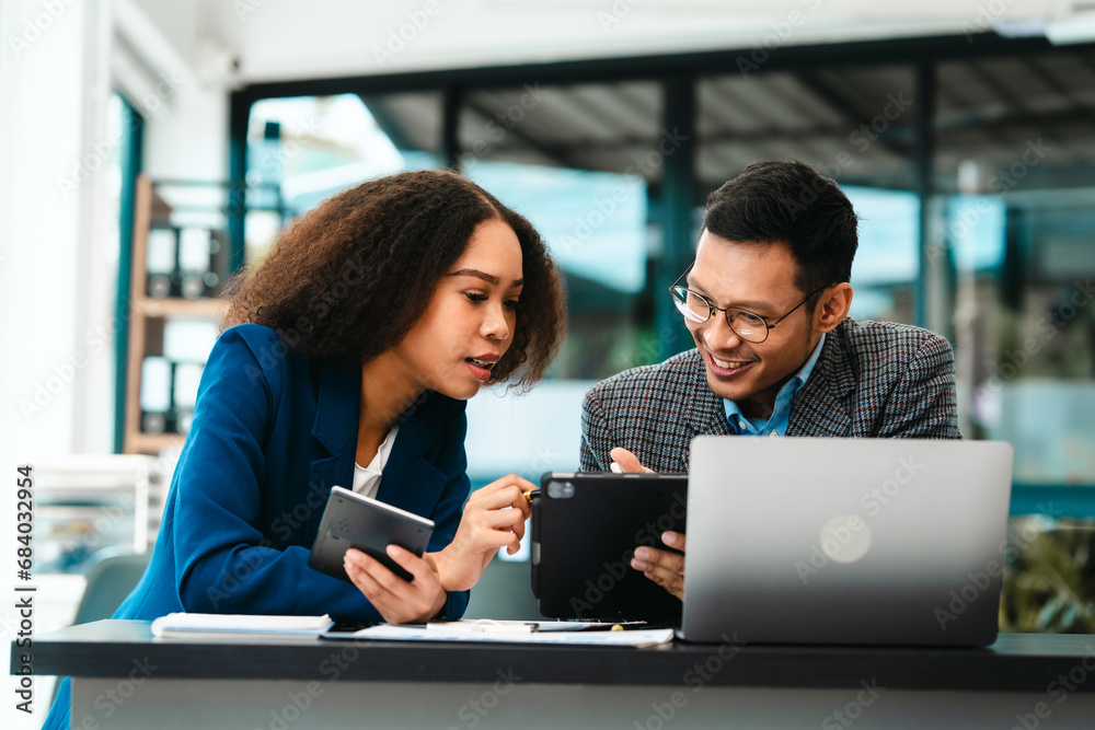 Asian business man and African American woman engaging in business discussion, possibly about merger or joint venture. two companies become one, one of companies often survives while other disappears Asian business man and African American woman engaging in business discussion, possibly about merger or joint venture. two companies become one, one of companies often survives while other disappears