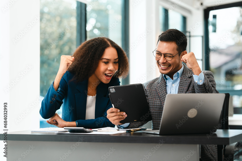 Asian business man and African American woman engaging in business discussion, possibly about merger or joint venture. two companies become one, one of companies often survives while other disappears