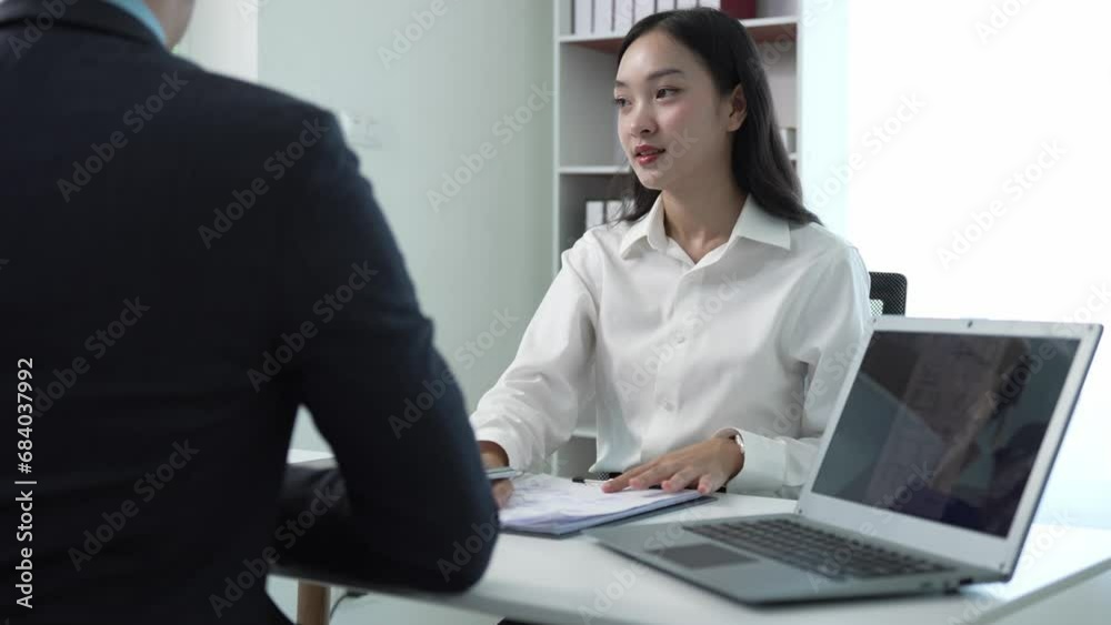 A successful businessman interviews a smart young woman for work in a respectful, professional atmosphere with a busy conversation. Two sides in modern office A successful businessman interviews a smart young woman for work in a respectful, professional atmosphere with a busy conversation. Two sides in modern office