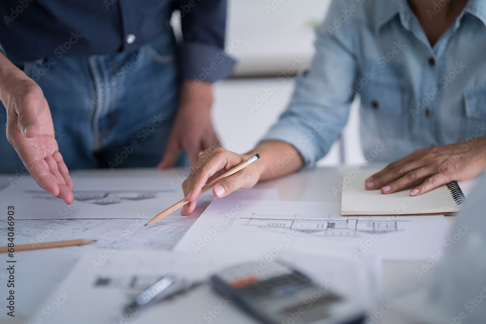 Two engineer architect discussion and inspecting sketching about interior architectural building on blueprint to analysis technical for construction plan while working together in workplace site Two engineer architect discussion and inspecting sketching about interior architectural building on blueprint to analysis technical for construction plan while working together in workplace site