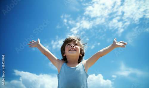 Relaxed boy breathing fresh air raising arms over blue sky at summer.