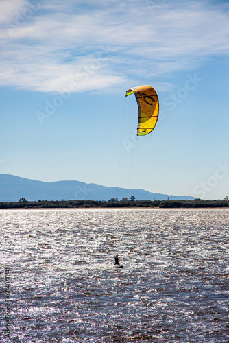 Kitesurfer rolls and maneuvers through the waves on the river