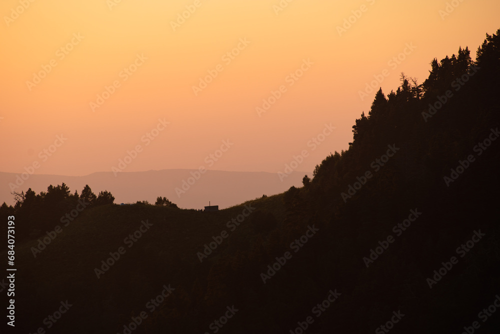 hills, forest and the sun setting behind the mountains hills, forest and the sun setting behind the mountains