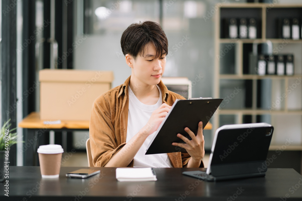 Young business man working at office with laptop, tablet and taking notes on the paper. Young business man working at office with laptop, tablet and taking notes on the paper.