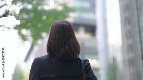 ビジネス街を歩くスーツ姿の女性の後ろ姿