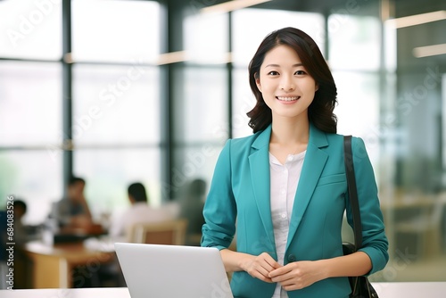 Young woman wearing a blue jacket standing confidently in front of a laptop computer with a smile on her face. Generative AI