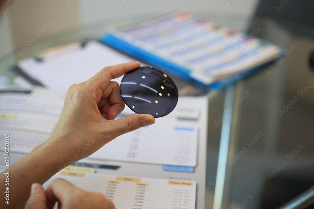 close up of a hand holding a lens glasses 