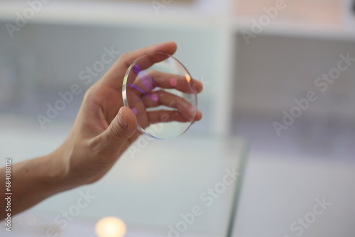 close up of a person holding a lens glasses 