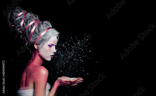 Beautiful model woman with creative makeup and white snow on black background photo