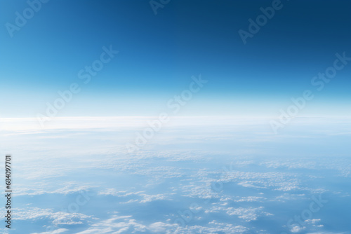 aerial view to the blue earth's surface with atmospheric haze and clouds