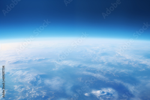 view from the space to the blue earth's surface with atmospheric haze and clouds